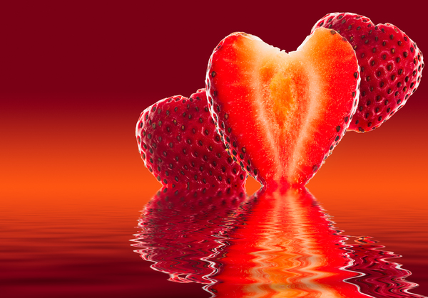 Fresh sliced strawberry in heart shape reflected by Steve Heap
