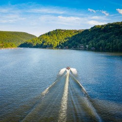 Speedboat on Cheat Lake on a summer evening with boats docked in