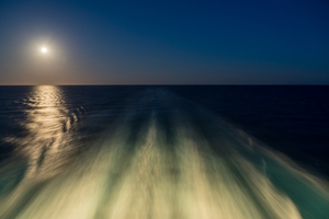 Moon over the wake of cruise ship travelling at speed