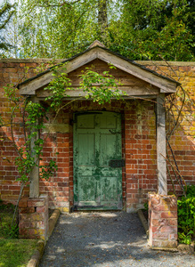 Painted green door and porch in walled garden wall