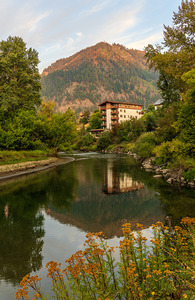 Alpine German apartment building relfects in River Wenatchee in 