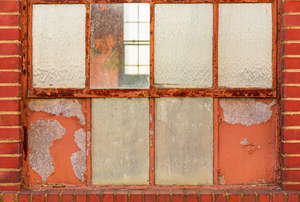 Old rusty window in warehouse painted red and orange