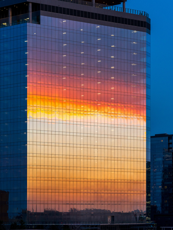 Brilliant sunset reflected in the glass of new office building by Steve Heap