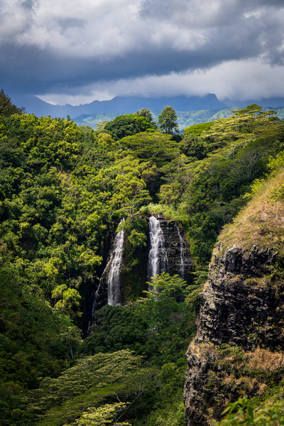 Opaekaa Falls sunlit as dark storm clouds gather over the hills Print