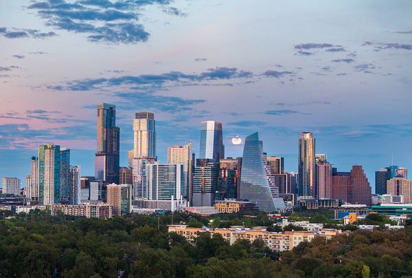 Distant view of Harvest moon in the Austin skyline at sunset by Steve Heap