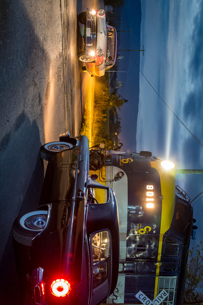 Two vintage cars racing to railroad crossing by Steve Heap
