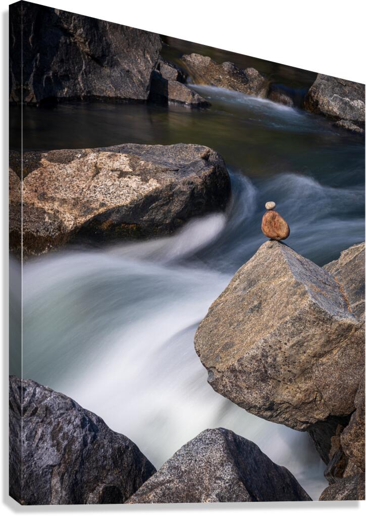 Pebbles balanced on rocks in raging river illustrating resilienc Canvas Print