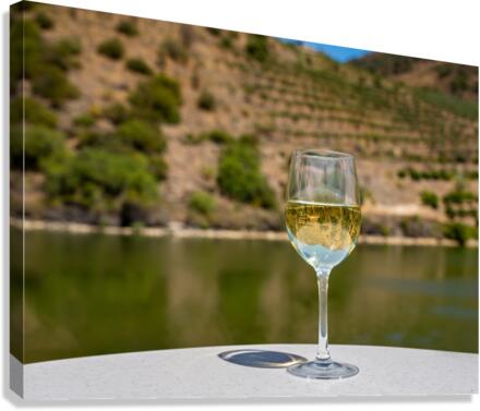 Glass of white wine by Douro river in Portugal Canvas Print