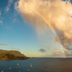 Rainbow over Hanalei bay in panorama across the ocean