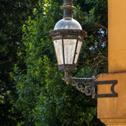 Historic english street lantern attached to warm stone building