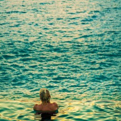 Womans head against infinity edge pool
