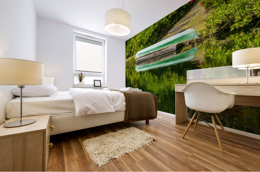 Green canoe on dock reflecting into calm lake or pond in garden Mural print