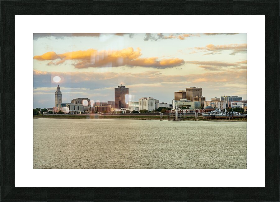 Skyline of Baton Rouge at sunset over river barges  Framed Print Print