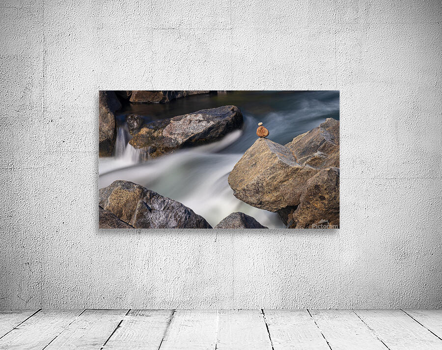 Pebbles balanced on rocks in raging river illustrating resilienc Wall Preview