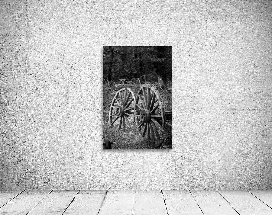 Two old wooden cartwheels against wood cart Wall Preview