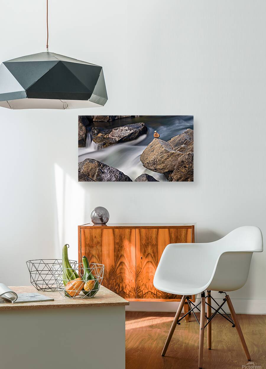 Pebbles balanced on rocks in raging river illustrating resilienc Reproduction