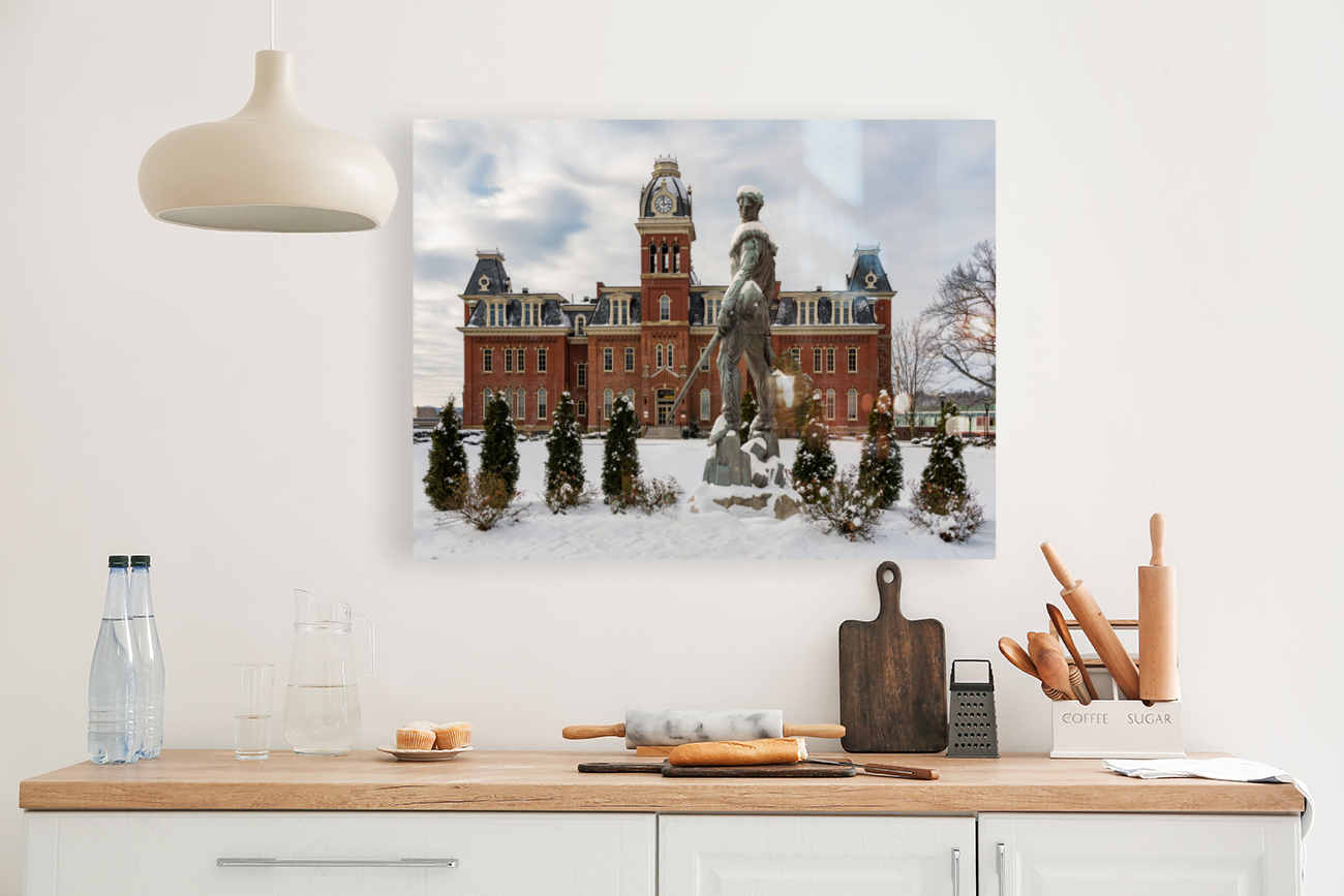 Mountaineer statue against Woodburn Hall Reproduction